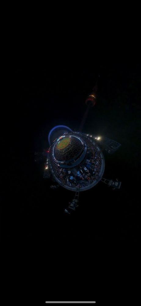 A fisheye lens photo of the skydome where the zoom is such that the light standards act as legs, the dome as a head, and the stadium as the round body. A distant light source resembles a sun towards which the turtle moves.