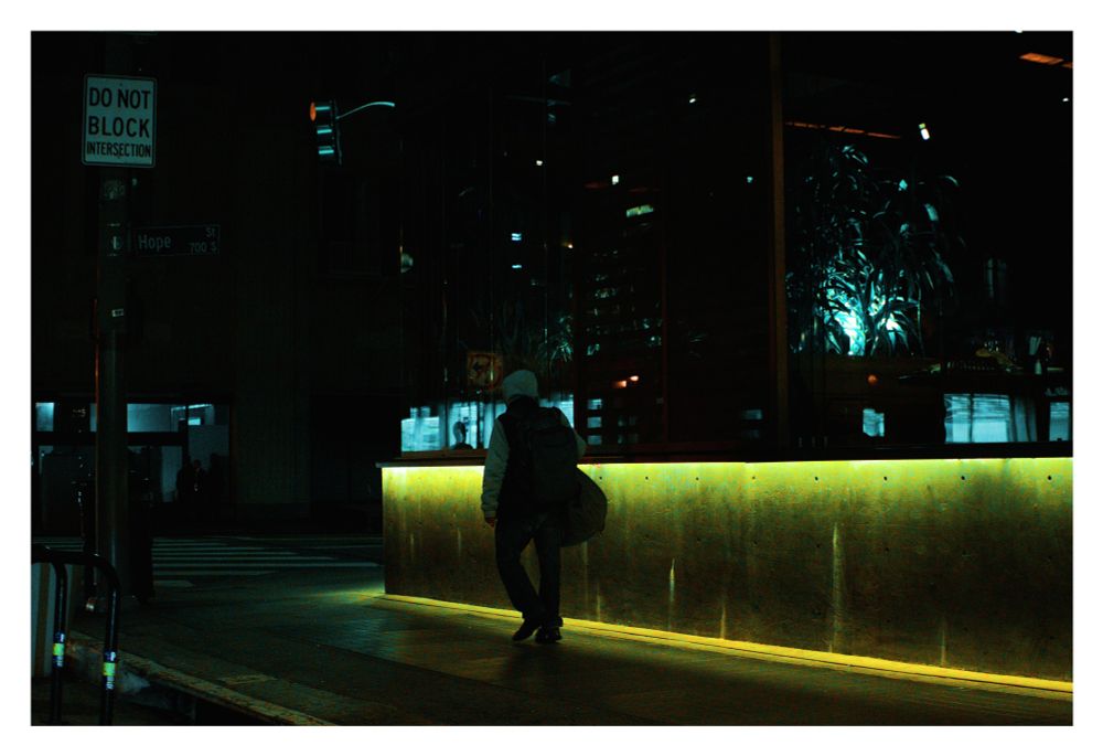 A man carrying a bag walks down the street.