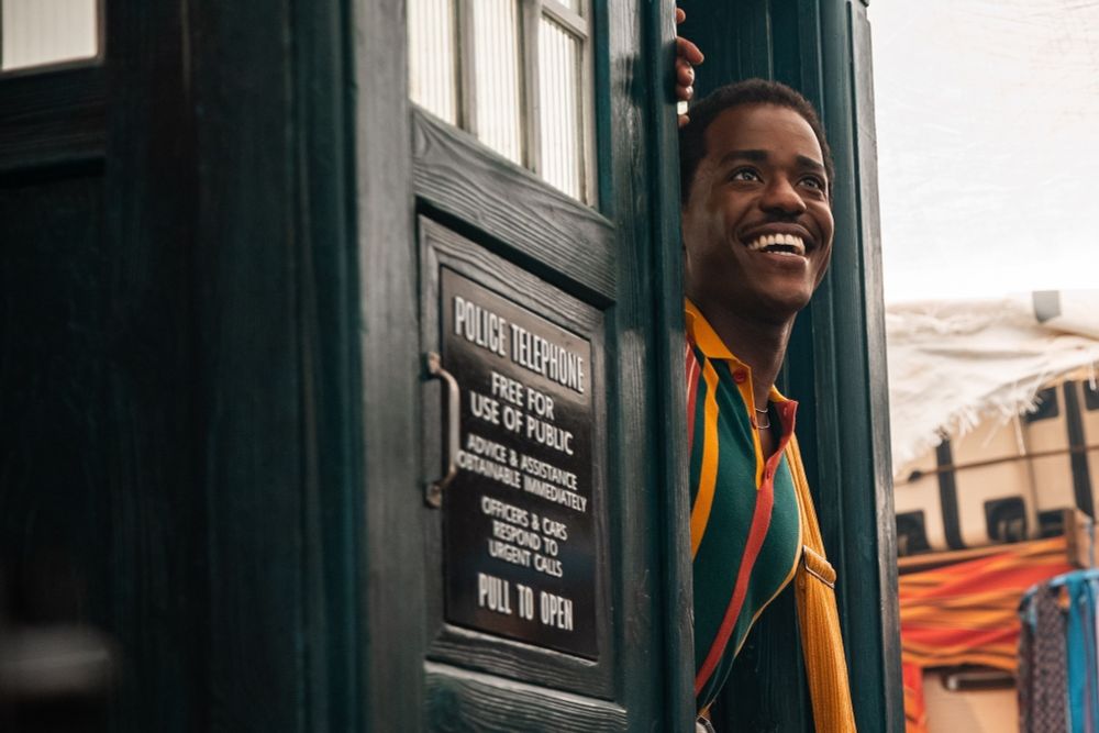 Ncuti Gatwa as the Fifteenth Doctor from Doctor is joyfully looking out from inside the TARDIS.