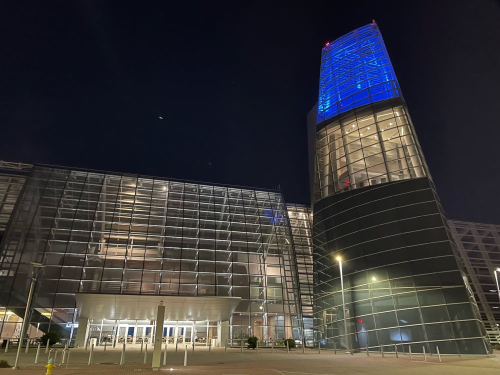 Va Beach convention center in the dark - the glass building is lit from within and the tower glows blue