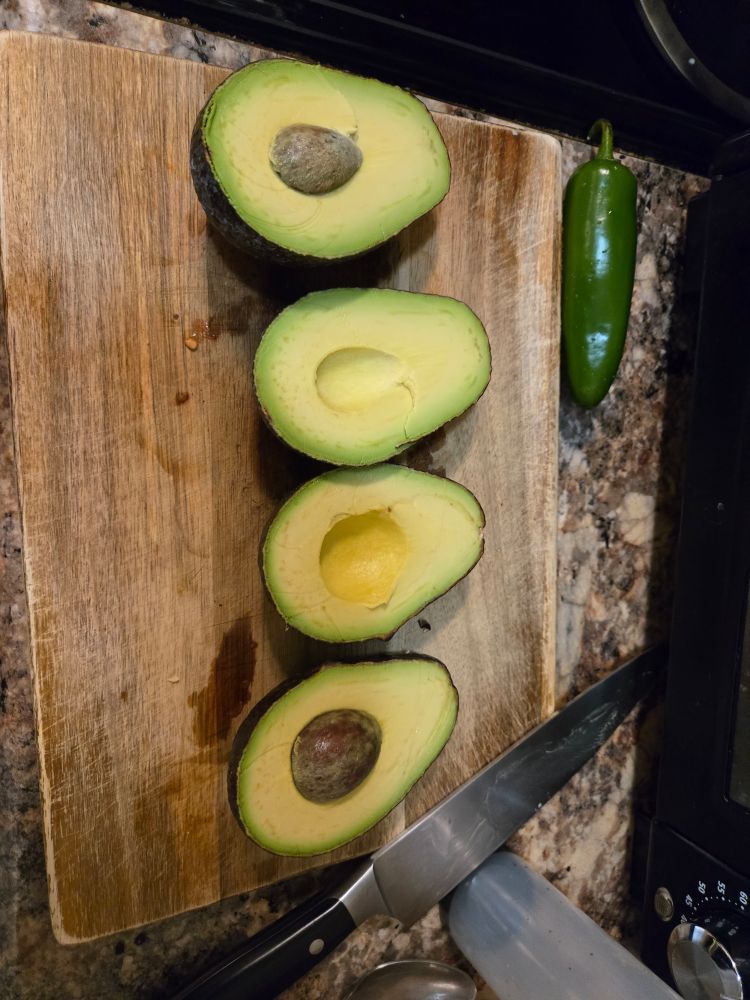 Two avocados, the exact ripeness to make Guacamole.