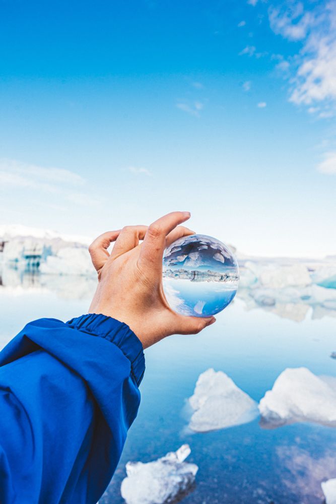 Holding up a lensball with a glacier lagoon in the background