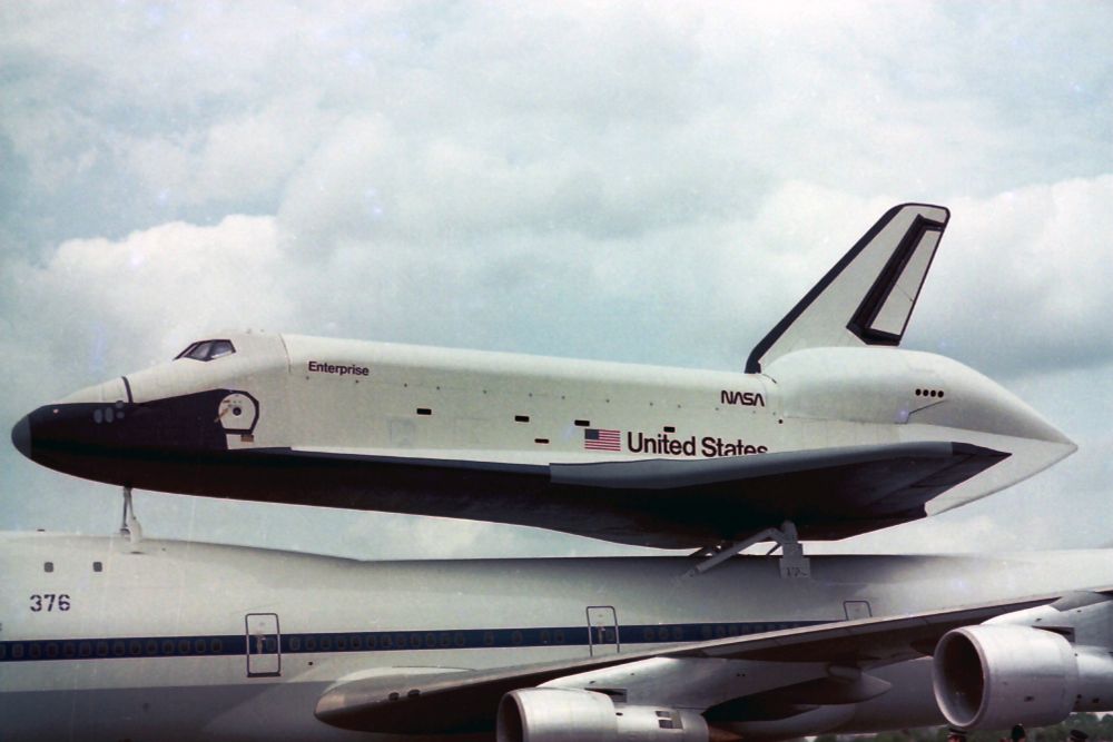 Space Shuttle Enterprise sits beautifully on top of the 747 against a backdrop of clouds and bluesky. Scanned photo from June 1983.