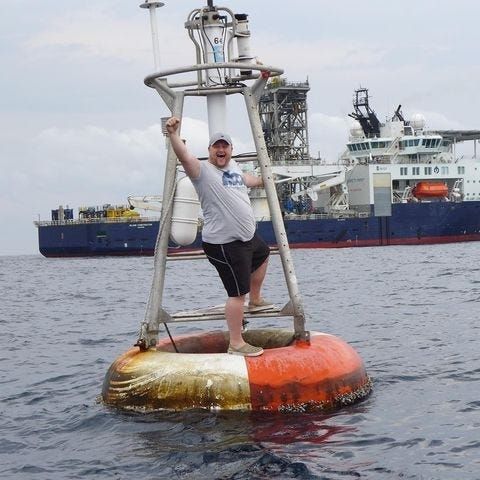 Man standing on the bouy dubbed 'null island'