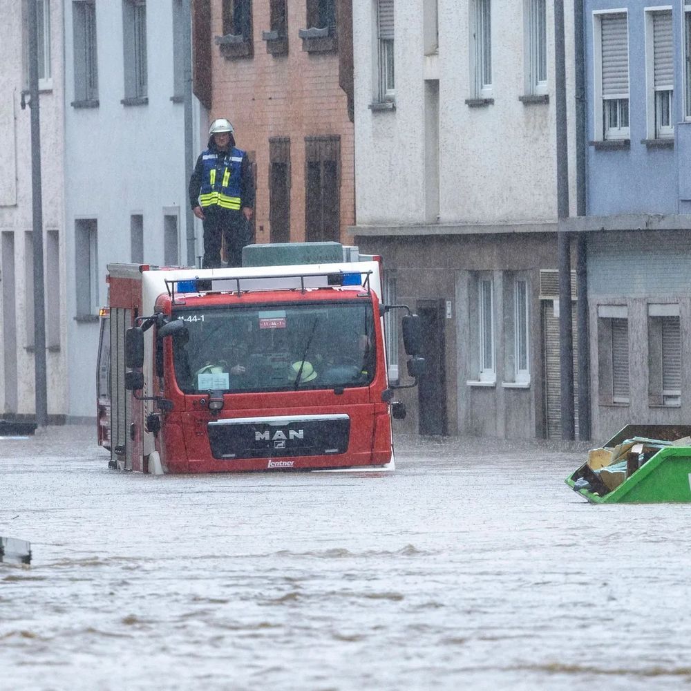 Hochwasser im Saarland: Ein Feuerwehrauto steckt in den Fluten fest. Ein Feuerwehrmann hat sich auch das Dach des Fahrzeugs gerettet