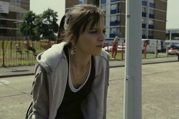 Mia sitting on a wall outside a council estate. From the movie Fish Tank (2009)
