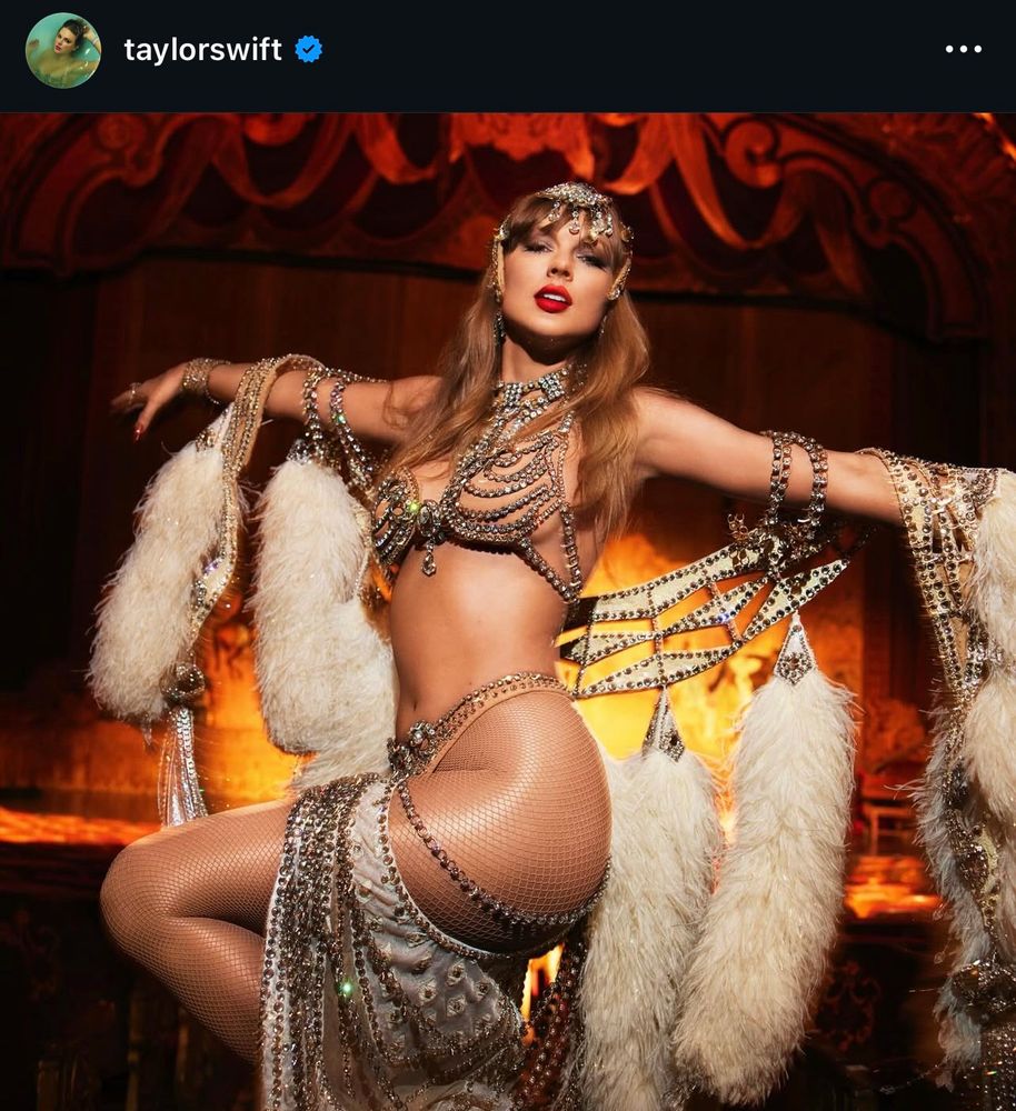Instagram post by Taylor Swift. She's wearing a showgirl outfit with a lot of stones and crystals and nude fishnet tights. The photo shows a lot of skin. 