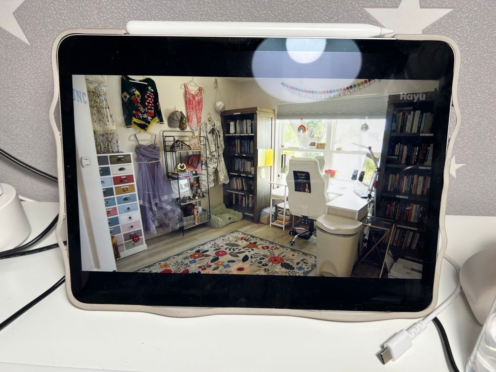Photo of an iPad playing a TV show, showing a hobby room with Taylor Swift related items and costumes