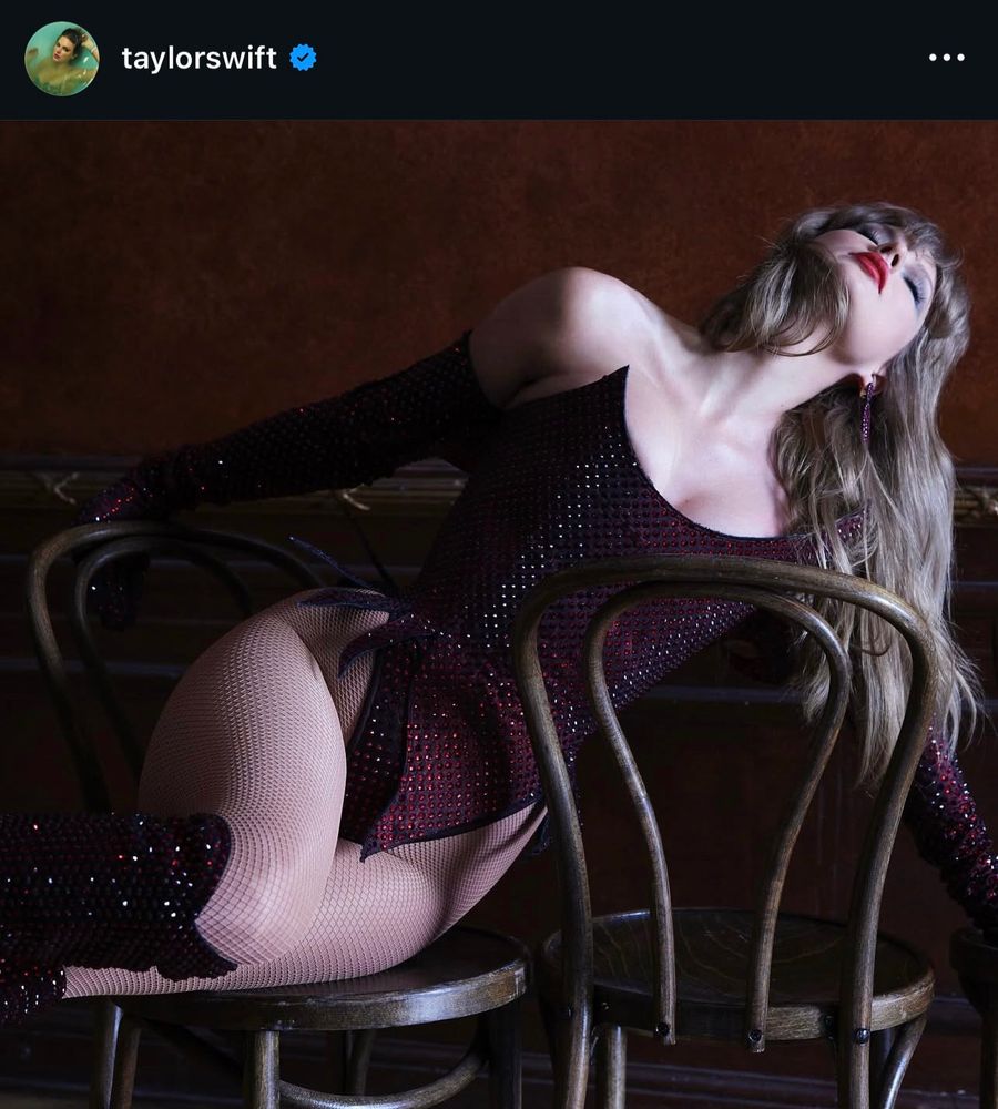 Instagram post by Taylor Swift. It's a dark and sexy photo, she's wearing a rhinestoned bodysuit with sharp pointed edges on the bust and the crotch. She's leaning over two chairs with her head tilted back and her eyes closed.