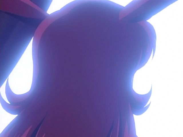 the serious and brunette (including her rabbit ears) Inaba is looking away from the camera but turns to face it and as she does her hair turns blonde and her ears turn white with black tips as she switches to Mimika. When her face is in view her eyes are more cartoony and bigger and she has big anime tears and is holding her white gloved hands in front of her chin.
from Usagi-chan de CUE!! ova episode 2