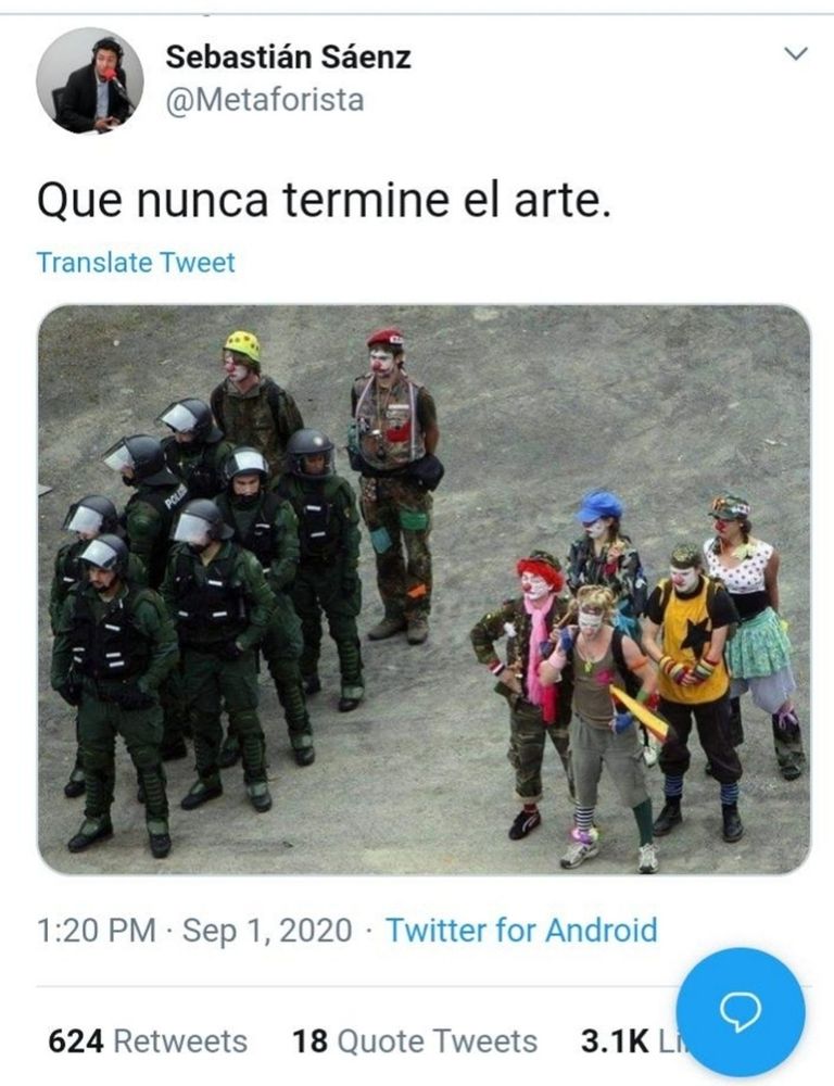 Several soldiers in riot gear. Next to them are ppl dressed as clowns also standing in formation 

The tweet by Sebastian Sáenz (@metaforista) says que nunca termine el arte