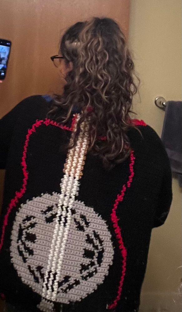 picture of the back of han’s cardigan depicting sammie’s guitar from the film sinners 