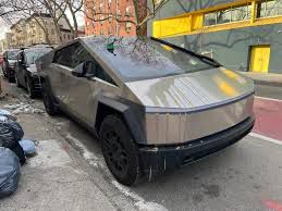 Cybertruck on urban street with broken eggs dripping off the hood.