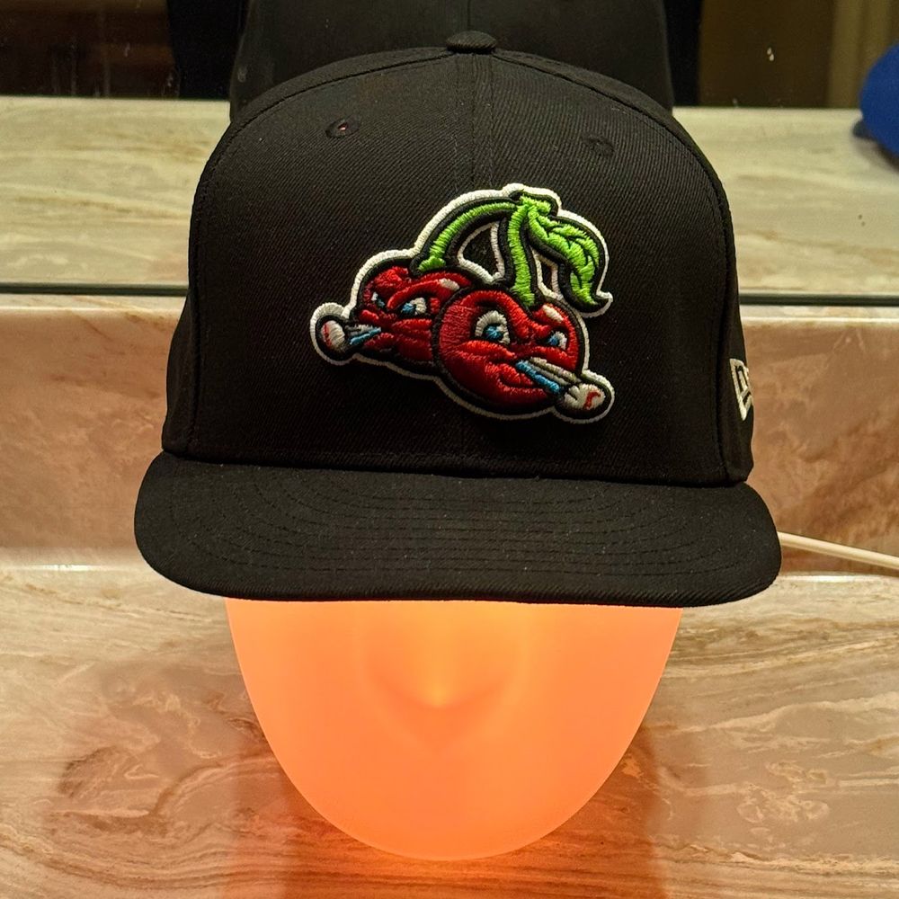 Thomas Headison is glowing orange and wearing a black Traverse City Pit Spitters baseball cap.