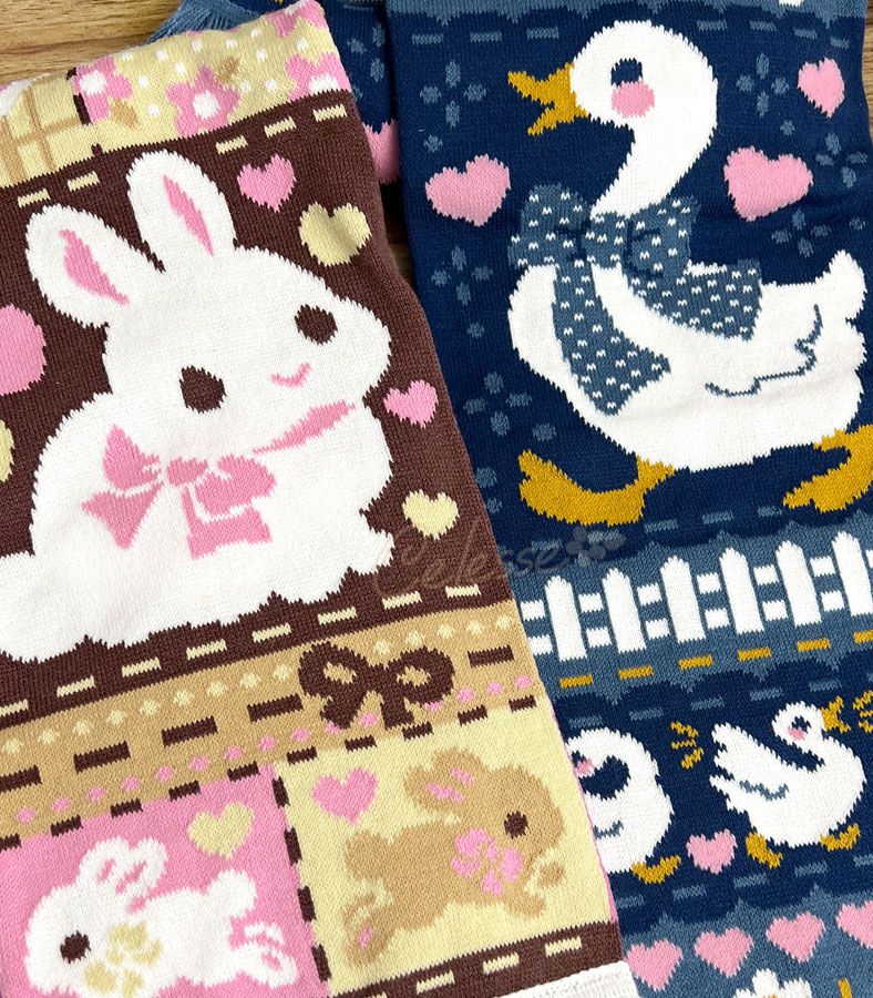 A cropped close-up sneak peek photo of two knit scarves. The left design is made of warm browns, pinks and yellows and features a rabbit themed patchwork design. The right features a vintage white goose theme with deep muted blues and a touch of yellow and pink.