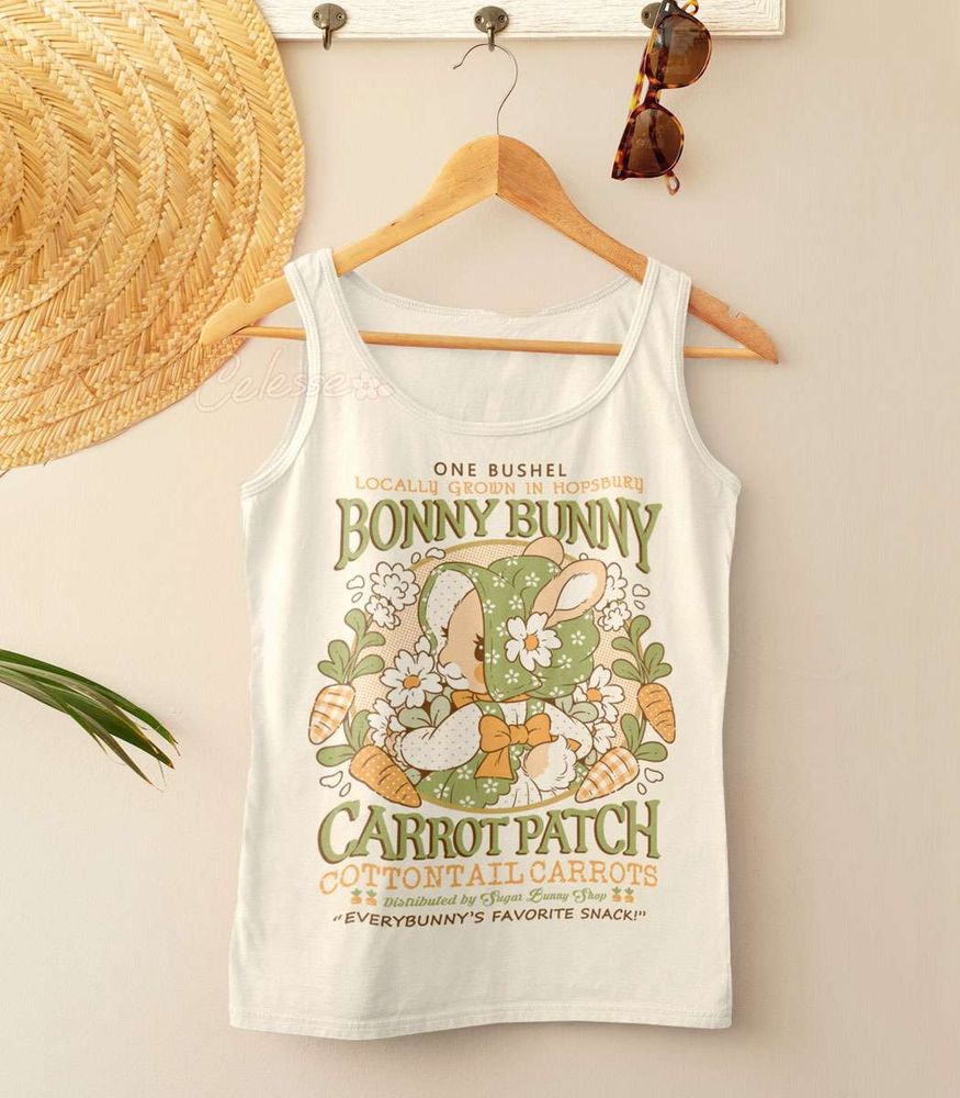 A natural-colored shirt on a wooden hanger with a straw hat and sunglasses. The print features a faux logo for Bonny Bunny Carrot Patch with a rabbit in an old-fashioned bonnet and dress holding flowers.