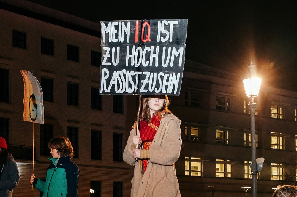 Frau auf Demo mit Plakat:
"Mein IQ ist zu hoch um Rassist zu sein"