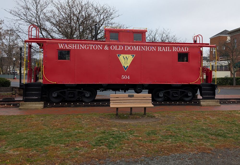 A caboose along the W&OD Trail with holiday lights.