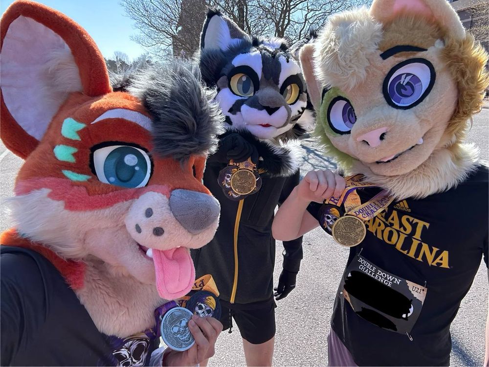 Three partial fursuiters holding up medals. 