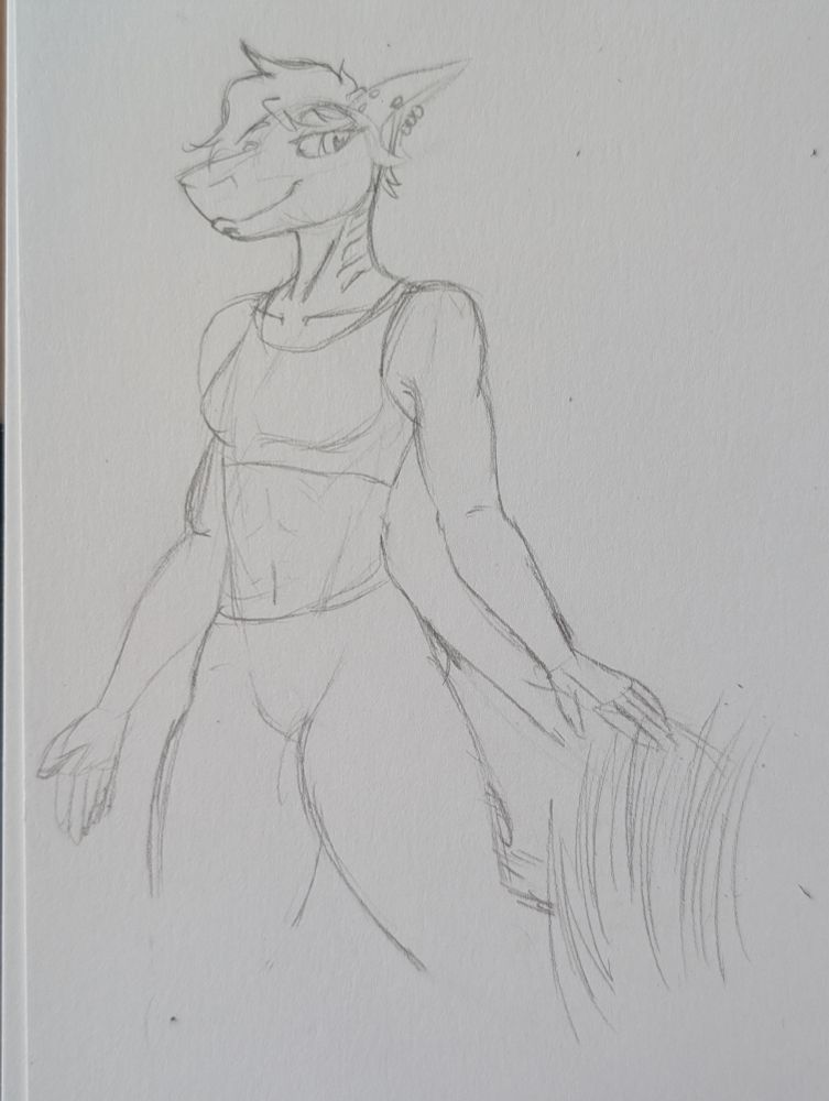 Jann in a sports bra and leggings running her hand along some grass