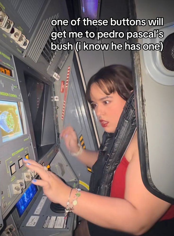 frame de um tiktok onde uma garota usando uma blusa vermelha está apertando um painel cheio de botões. o texto diz “one of these buttons will get me to pedro pascal’s bush (i know he has one)”