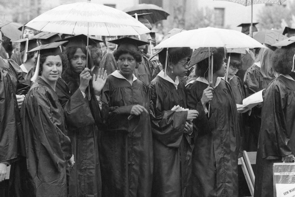 CMU students huddle together under umbrellas. Image from the University Archives.