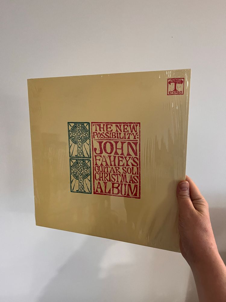 John fahey’s ‘the new possibilities’ on vinyl.

A yellow cover with a green woodblock print of two crosses and a red woodblock print of the album info forming a square in the centre 