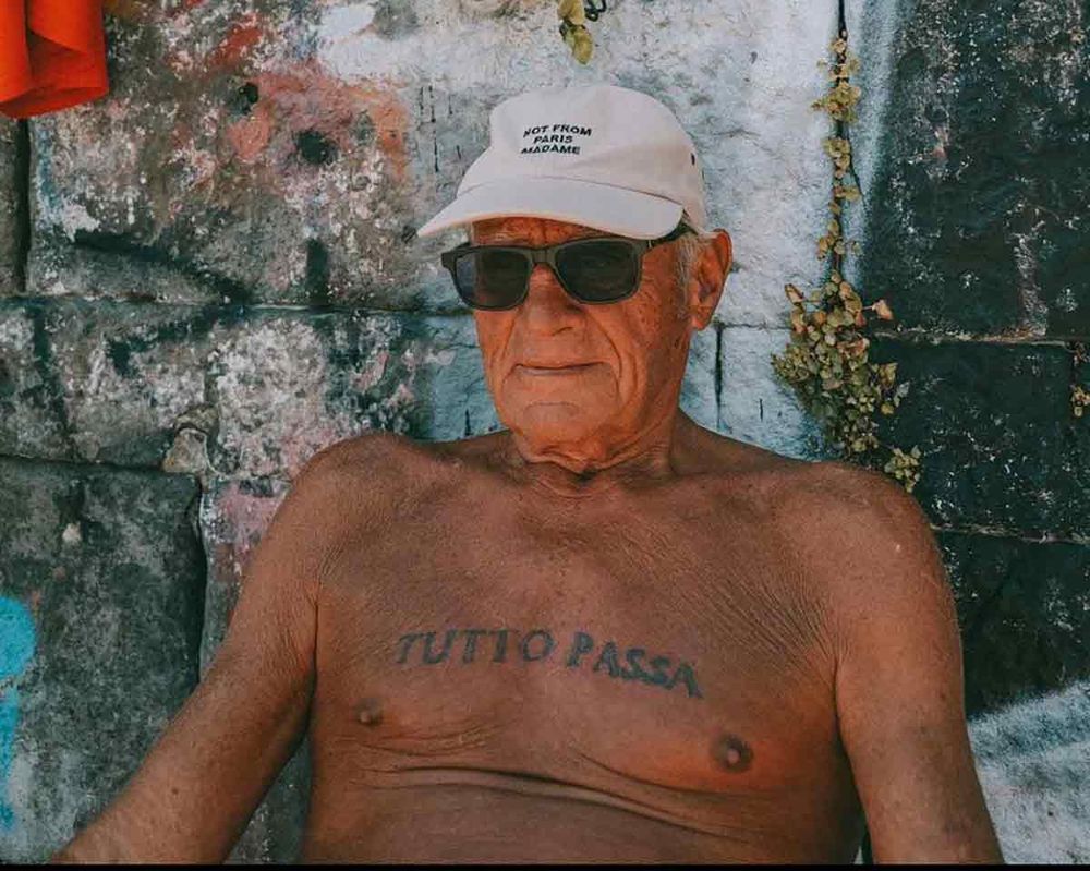 señor italiano moreno con tutto passa tatuado en el pecho