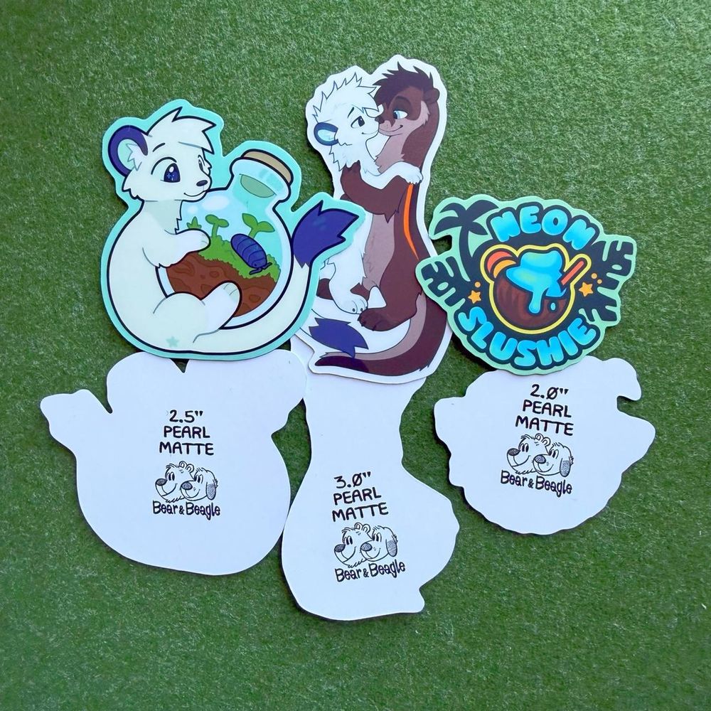 A photo of 3 different sticker designs (A stoat holding an isopod terrarium, a stoat and an otter embracing, and a Neon Slushie logo sticker) next to each other, with the same designs flipped over to show the printing on the back. #FurryArt