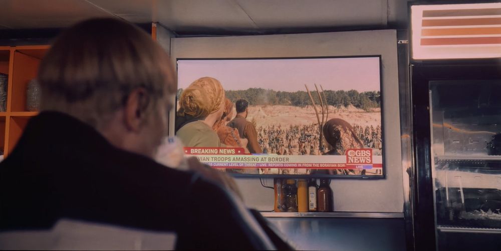 Guy Gardner watching a news report on Jarhanpur from Superman (2025)