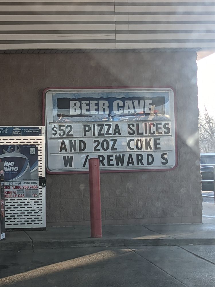 it's a sign at a gas station that says "$52 PIZZA SLICES AND 2OZ COKE W/ REWARDS" when i believe it's actually advertising a $5 deal for 2 pizza slices and a 20oz coke