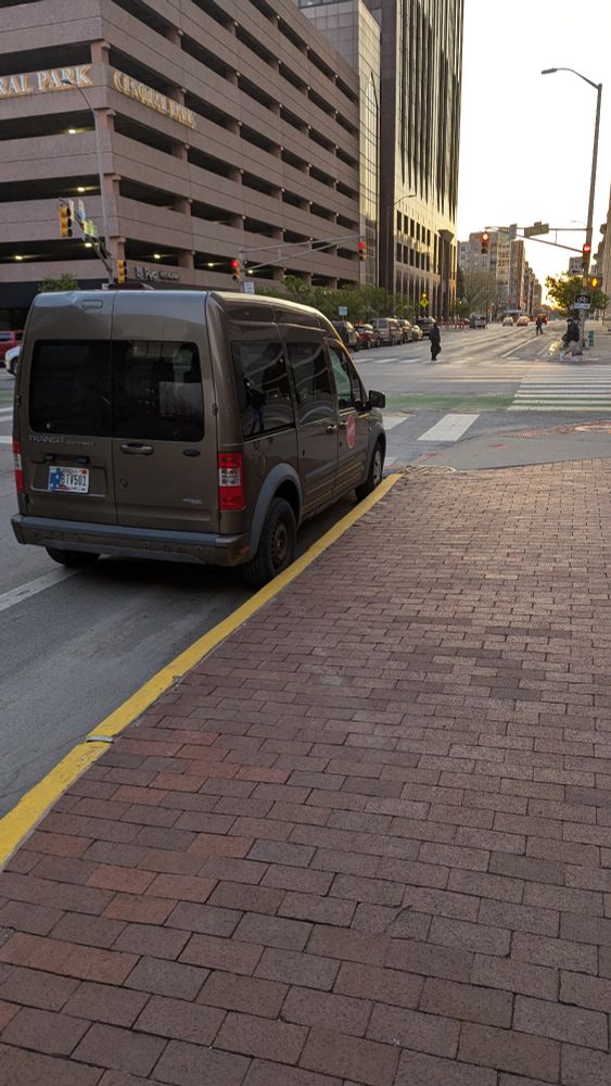 Work van parked in bike lane on New York Street at Illinois.