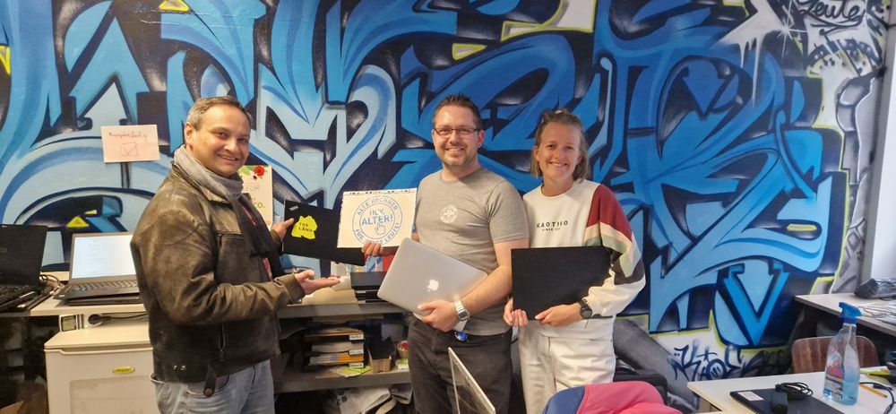 Eine Gruppe von Menschen, die Laptops halten und lächeln.