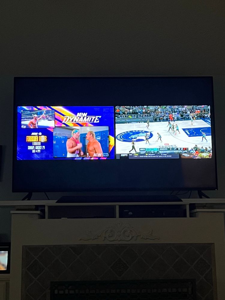A television has both AEW Dynamite on and the New York Liberty vs. the Minnesota Lynx on it.