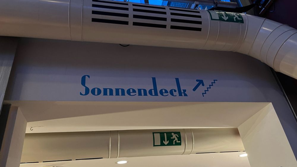 Wegweiser zum „Sonnendeck“, mit Pfeil aufwärts in die obere Etage.