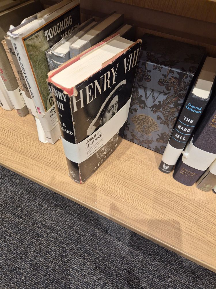 A notebook made from a worn hardback cover of Pollard's Henry VIII, on a bookshop shelf 