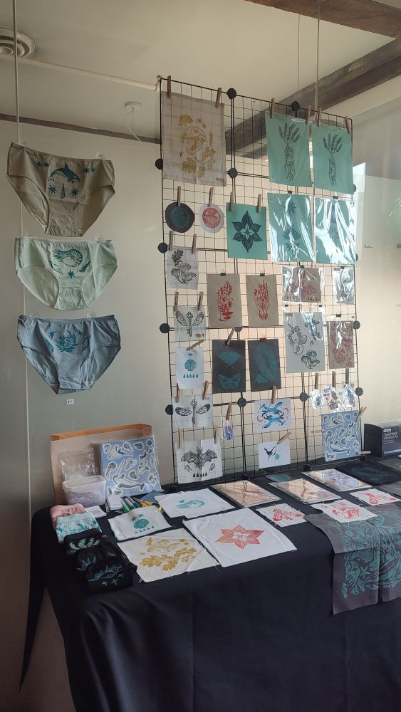 A photo of our last market at Patchwork art studio. It shows our paper prints, sew-on patches, stickers sheets and printed panties. The photo doesn’t shows our upcycled printed clothes and bandanas.