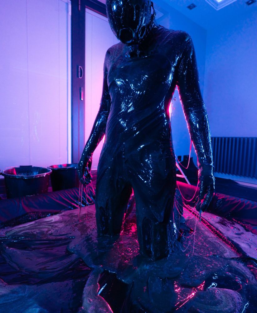 A drone dripping in black, blue and pinkish slime and light.
