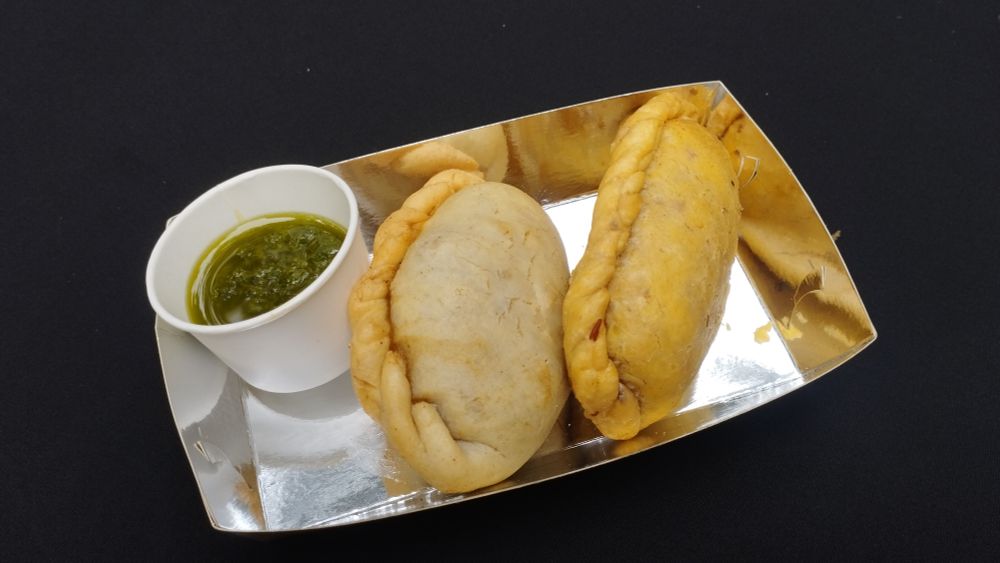 Dos empanadas rellenas de carne de res con chimicurri