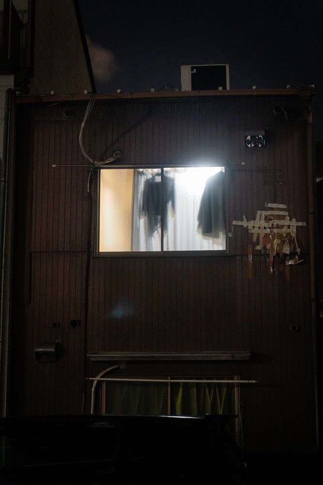 Cloths hang in a frosted glass window in a backstreet in Osaka's Nishinari-ku district. 