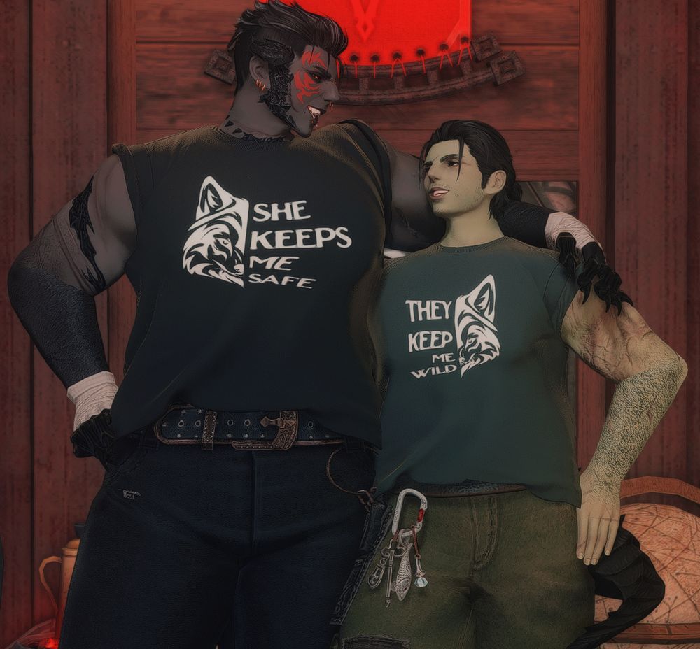 Fornax (an au roe: roegadyn and au ra mix) and Ryssrael (a roegadyn) wearing matching graphic tee shirts. Fornax's shirt is black with a wolf face image on the left that says "SHE KEEPS ME SAFE" while Ryssrael's is green with a wolf face image on the right that says "THEY KEEP ME WILD." Fornax has one hand on their hip and the other arm slung over Ryssrael's shoulders, while Ryssrael has a hand on her hip as well with her arm behind Fornax's back. They're both grinning big and wide at each other.