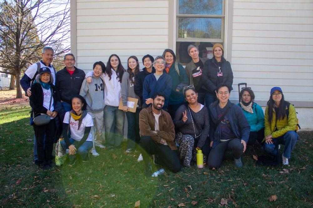 Group photo of 15 Asian Americans outside, some are wearing white API PA t-shirts, a few are holding clip boards