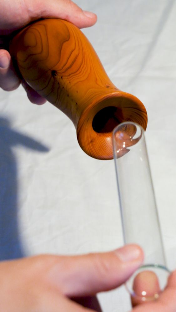 Putting a glass insert into a vase made from yew.