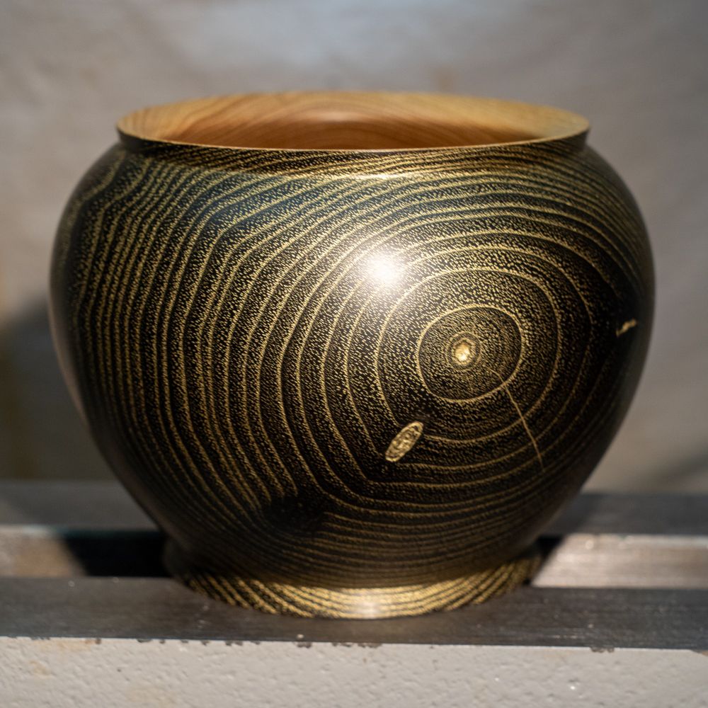 Side view of the bowl. I first brushed the wood, then dyed it and later applied the gold paste. After that, I removed the excess of the gold paste, leading to the nice contrast between gold and black.
