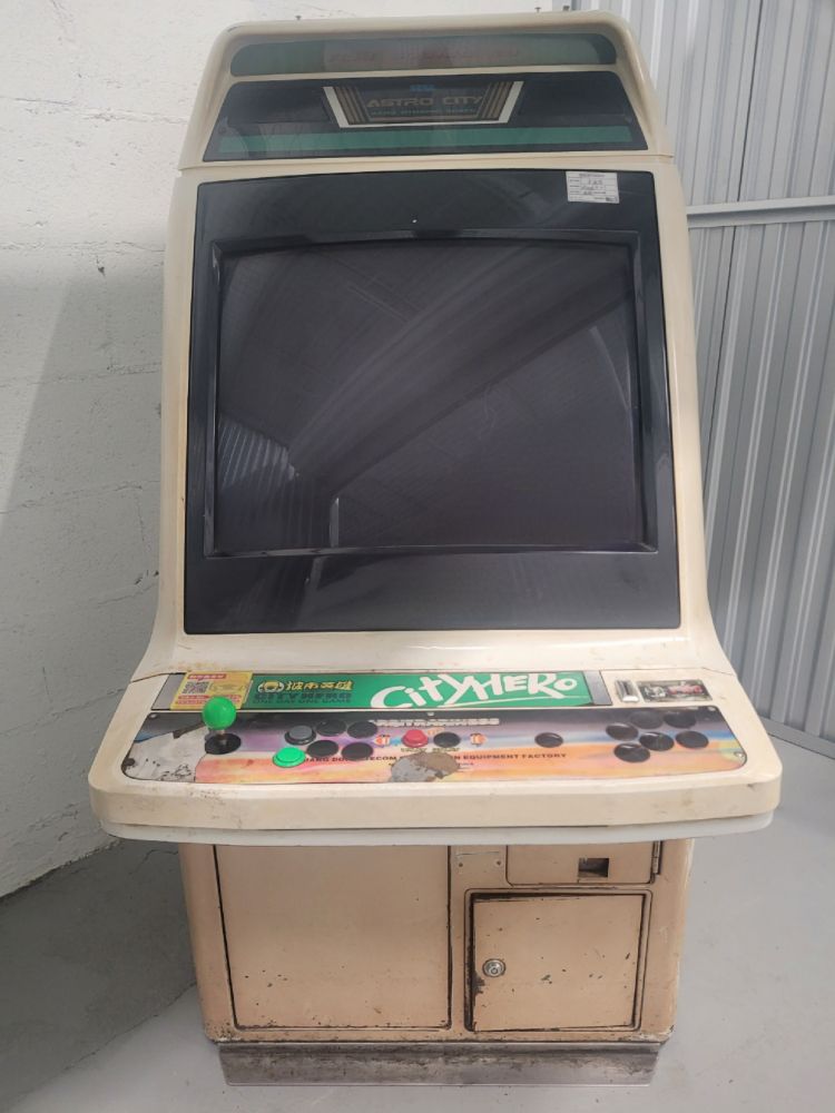 the cab as i received it. it has the same "city hero" decals (plus a new QR code), the coin sticker has been removed, and there is a similar stains(?) near the top of the CP. the button configuration seems to match what's in the original pic, but one of the green buttons has been swapped for a gray one.