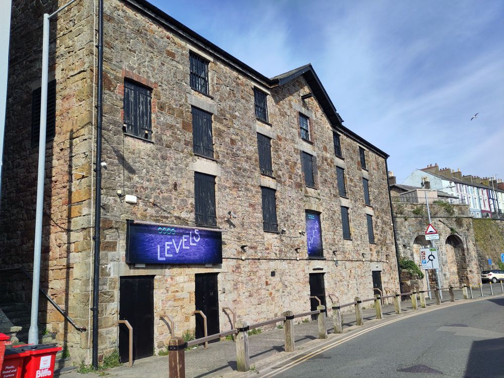 A brick warehouse building of some vintage. There appears to be five door-sized openings on the first floor, and another six on the second floor. Even when it was a functioning quayside warehouse, surely a couple would have done? You can overdo these things, you know... It's just showing off.