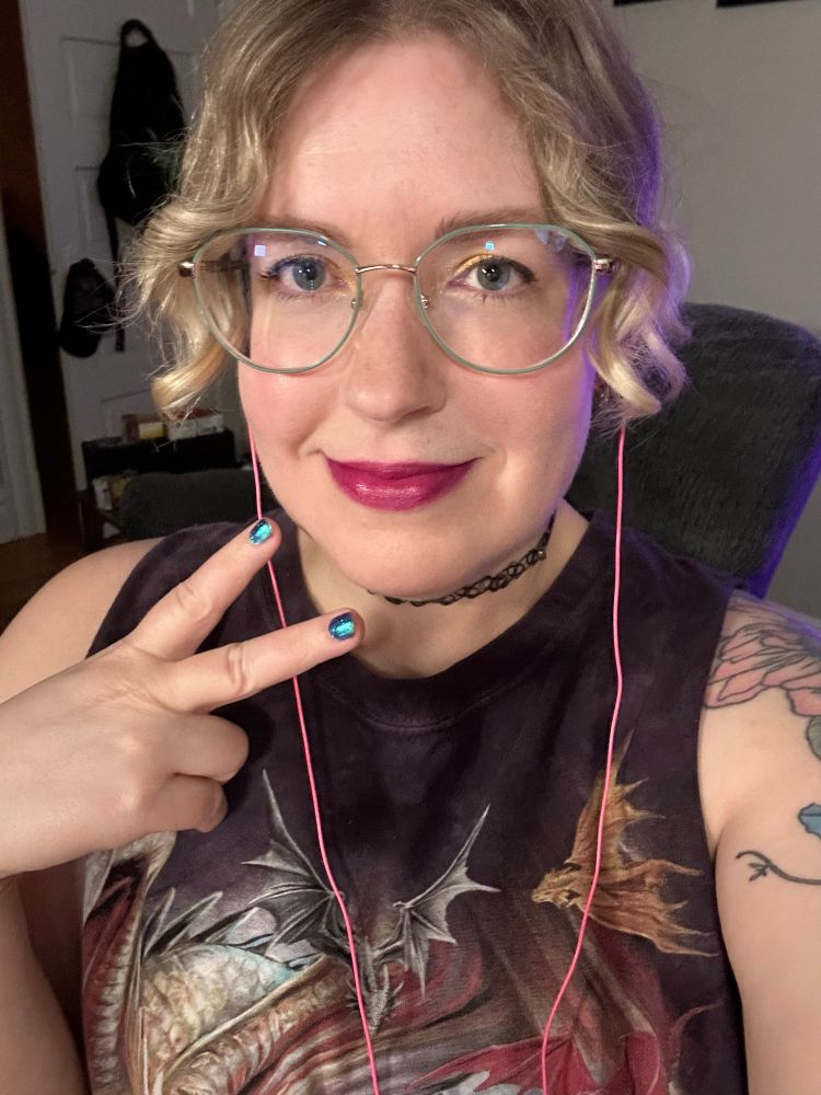 Jennifer wearing a dragon tank top giving a peace sign