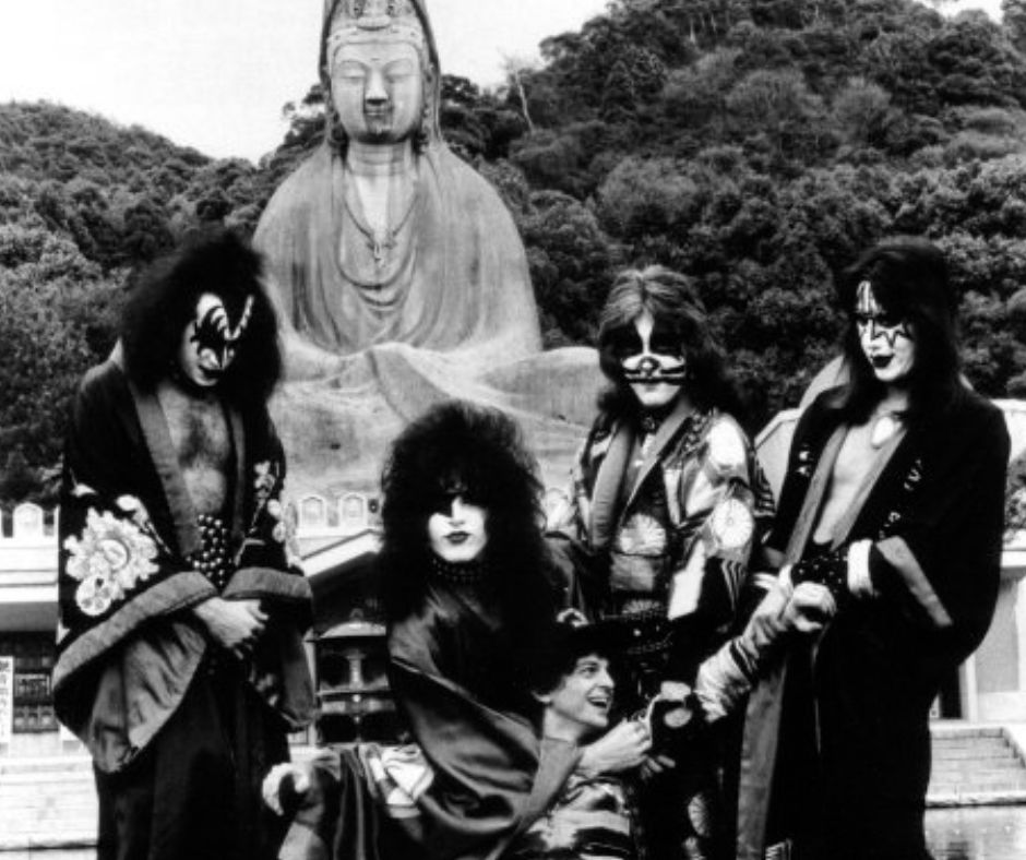 The band KISS surrounds and holds up Michael Gross. 