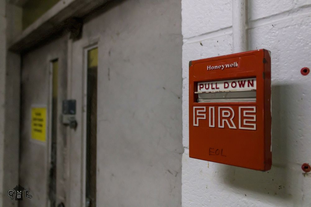 Fire alarm pull station next to a door.