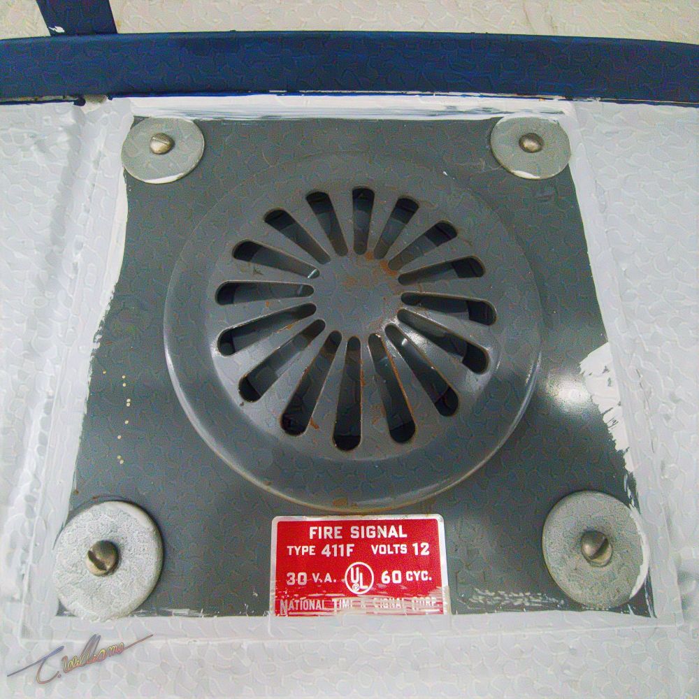 Antique electrical signalling device used for fire emergency warnings bolted to the wall.
